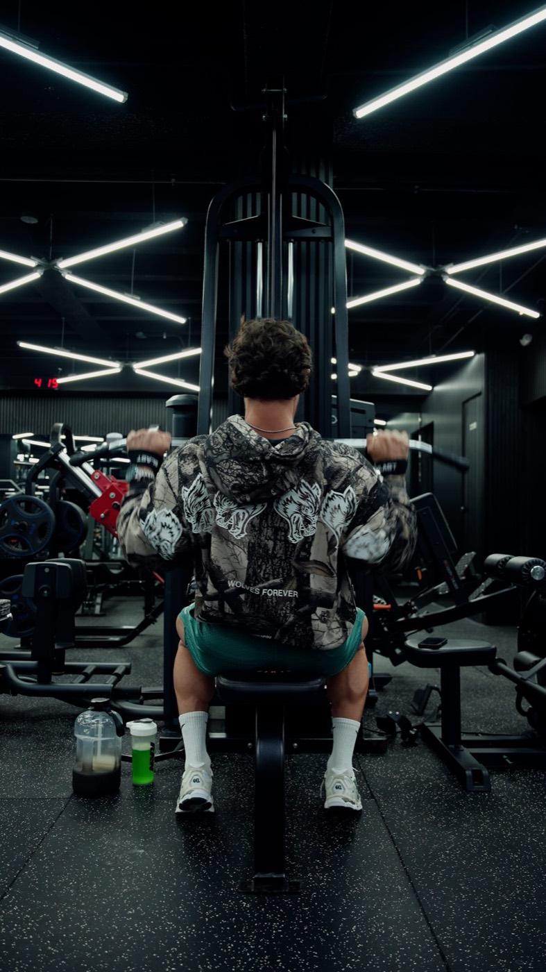 Atleta haciendo press de hombros en máquina durante una clase de Iron Method